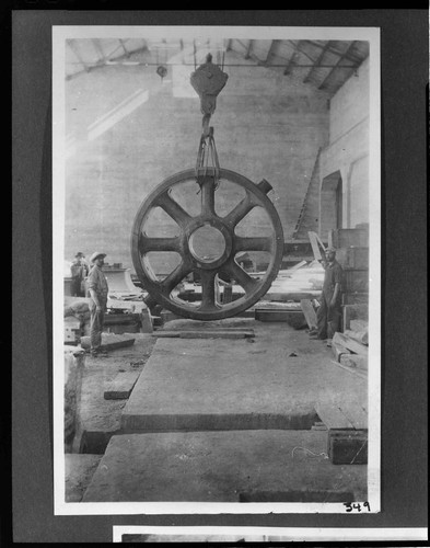 A construction crew unloading the rotor in the powerhouse using an electric crane at Kern River #1 Hydro Plant