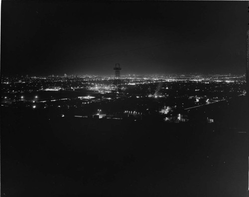 Night view of the city with oil derrick in the center of the shot