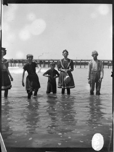 B.F. Pearson's family wading in the water at the beach