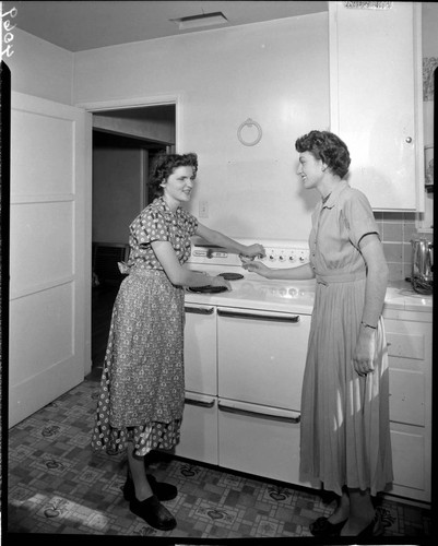 Two women baking in an electric oven