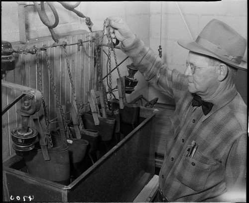 Man treating lineman's rubber gloves in tank