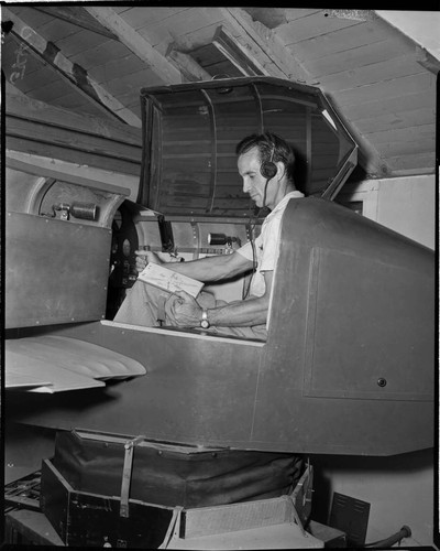 Man is sitting in what looks like a flight simulator