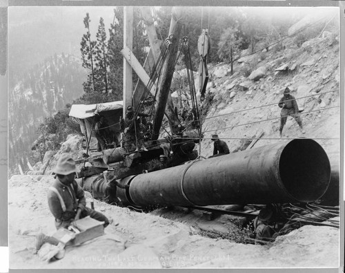 Skilled workmen install the last segment of German-made penstock pipe at Big Creek #1 Hydro Plant