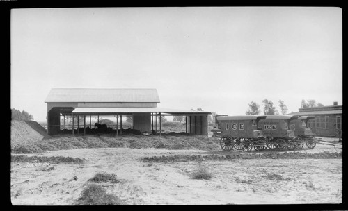 Buildings with two unhitched Imperial Ice wagons outside