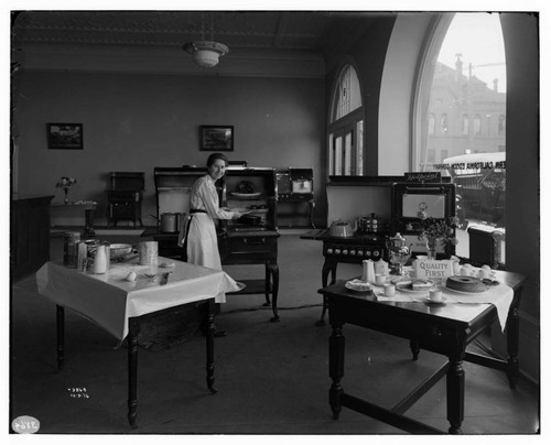 Miss Vera Ebert conducting a cooking demonstration with electric appliances at Edison Redlands Service Center