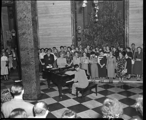 Edison chorus performing by Christmas tree in Edison General Office lobby