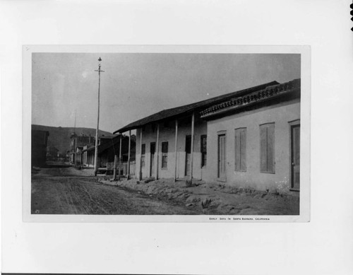 This 1887 view of East De La Guerra Street shows the old Antonio Arrellanes adobe and an arc-light on a high wooden pole