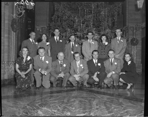 Group of Edison General Office workers in front of the Christmas tree in Edison lobby