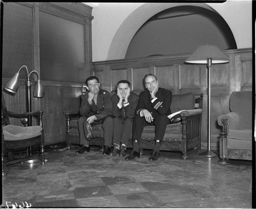 Three men seated in lobby