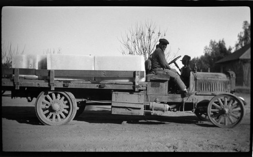 Two men in large flat-bed truck