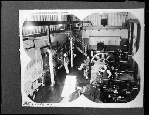 Three men standing next to the switchboard and generators in Mill Creek #1 Hydro Plant