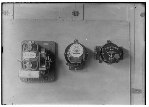 Three electric meters mounted in a group. All are different designs