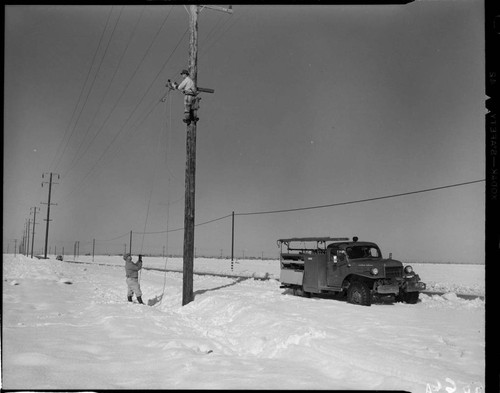 Linemen working on pole in snow