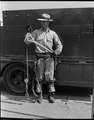 Lineman with Hi Line Hoist standing by line truck