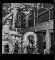 Man having his eyes examined; Men working at a steam plant or a water desalination plant