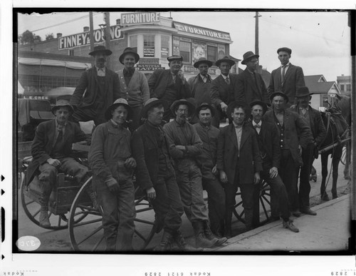 A group portrait of the Long Beach E.D.S. (Electric Distribution System) Gang leaning against a wagon