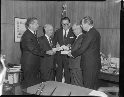 Executives posed exchanging checks