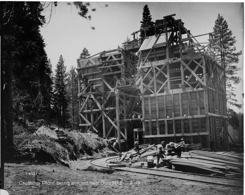 View of narrow gauge gasoline powered locomotive with empty dump cars at the dam site