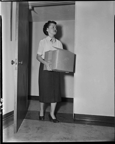 Lady carrying a box into a room