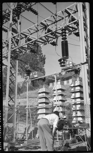 Engineer running tests in switch racks at electric substation