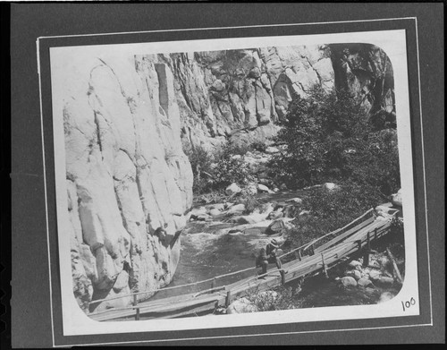 A man standing on a foot bridge across the Santa Ana River