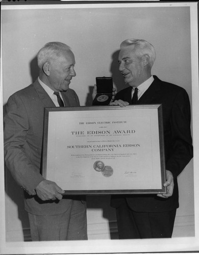 Edison Chairman of the Board Harold Quinton (left) accepts the Thomas A