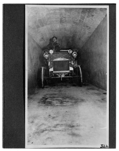 A man driving an automobile through the tunnel at Kern River #1 Hydro Plant