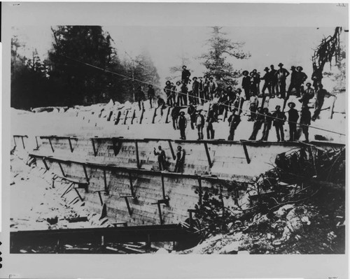 This rare photo shows the 1893 construction of the original timberfaced, rock-filled dam that impounded the millpond for C.B. Shaver's pioneer lumbering venture at Shaver Lake