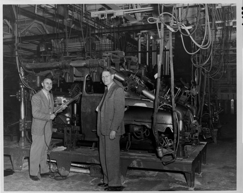 Wayne Johnson (right) views welding equipment at Ford's Wilmington Assembly Plant, during the conversion to 60-cycle operation, 1947