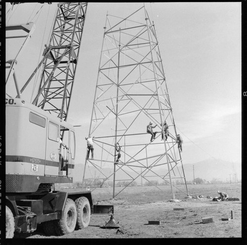 Transmission tower construction using a crane