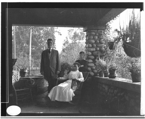 A woman, a teen-age boy, and a young boy on a porch