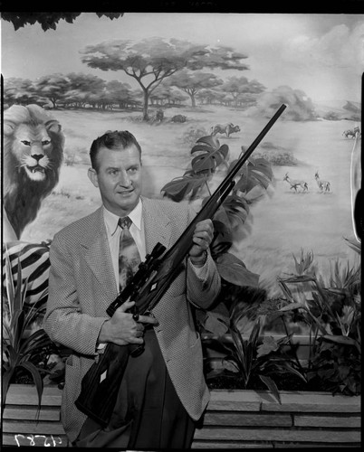 Man holding finished rifle with telescopic sight