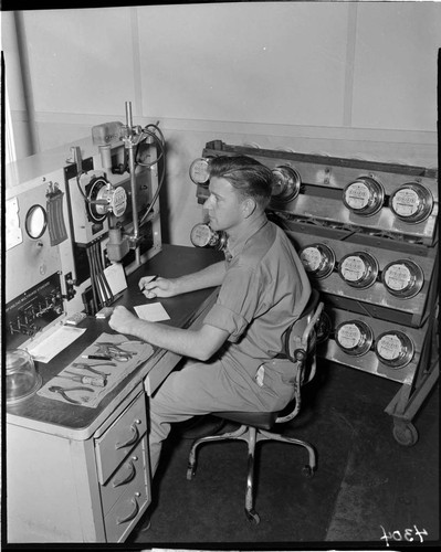 Young man at desk testing electric meters