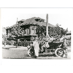 William Knapp standing next to an automobile in front of 3101 Champion Street at the intersection with School Street