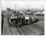 Oakland, California, mayor Clifford E. Rishell (on tractor) and other men commemorate the start of construction for the Bancroft Avenue Parkway near 98th Avenue in the city's Elmhurst district