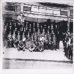 Italian band from the Balill'a Lodge of the Knights of Pythias pose in front of Frank Dezzutti's shop on Telegraph Avenue near 47th Street in the Temescal district of Oakland, California