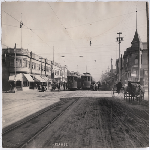 Two electric street cars board passengers at the corner of Fruitvale Avenue and East 14th Street (later International Boulevard) in the Fruitvale district of Oakland, California. Citizen's Bank in view. Image is labeled "Melrose" on front