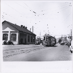 A street car rolls past the East Bay Street Railways Ltd. car barn on Telegraph Avenue at 50th Street in the Temescal district of Oakland, California. Tower Theatre in view on right