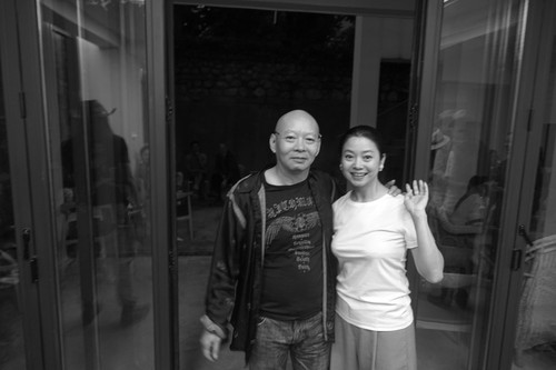 Yue Minjun and wife Yue Er in front of their family house in Dali 3 of 3