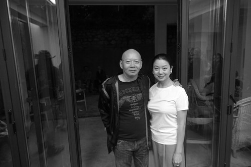 Yue Minjun and wife Yue Er in front of their family house in Dali 1 of 3