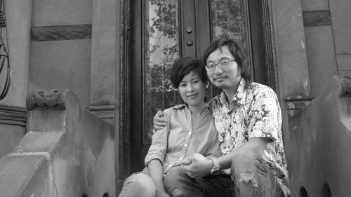 Jian Yi and wife in front of Brooklyn house 1 of 2