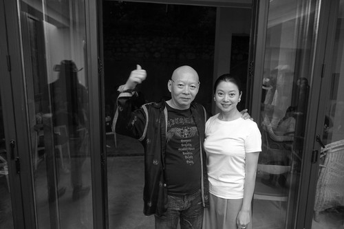 Yue Minjun and wife Yue Er in front of their family house in Dali 2 of 3