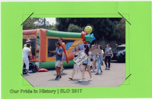 Central Coast Pride participants, one with a poster reading 'Silence is Violence: Resist,' June 2017