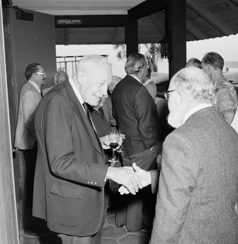 Roger Revelle shaking hands with William H. Thomas at Roger's 80th birthday party