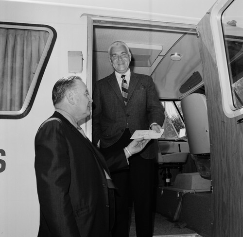 Sears Roebuck Company representatives awarding UC San Diego Chancellor William J. McGill (center) a check to pay for a new mobile unit (in background)