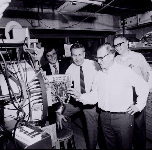 Walter H. Munk (foreground) and Bernard Zetler (right) showing a recording system to Michel J.M. Beguery and Jean-Pierre Levy, Scripps Institution of Oceanography