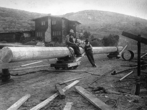Workers during the construction of the Scripps Pier with the Director's House in the background, Scripps Institution of Oceanography