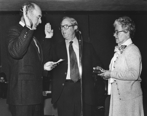 Henry W. Menard taking the oath of office as Director of the U.S. Geological Survey, with Cecil D. Andrus (left) and Gifford Merrill Menard (right)