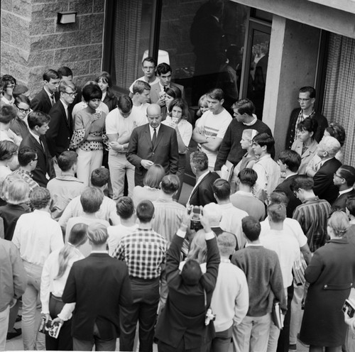 Clark Kerr and Edward Goldberg (back to camera) in discussion with group of students and faculty during installation of Galbraith as Chancellor, UC San Diego