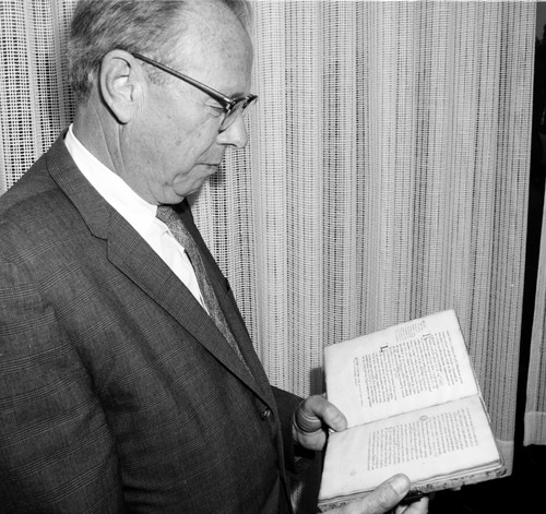 University Librarian Melvin J. Voigt with rare book